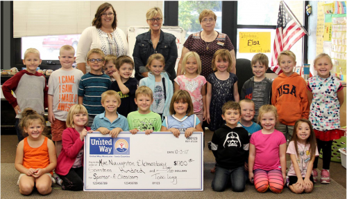 Group of youth with sponsor a classroom check